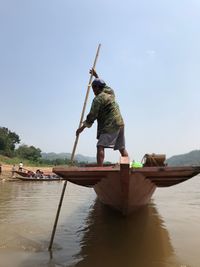 Man in boat against clear sky