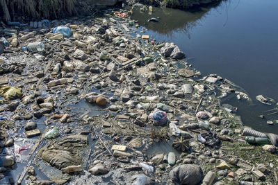 High angle view of garbage on rock by lake