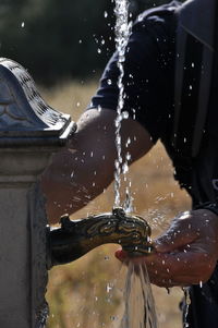 Man drinking water from fountain