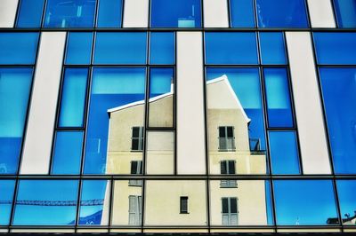 Low angle view of office building against blue sky