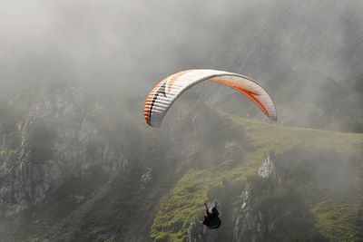 High angle view of man paragliding against mountains