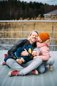 Father and two children walk in nature in autumn, spend time together, have fun.