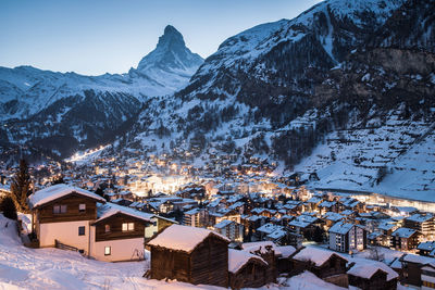 High angle view of snow covered houses and buildings against sky