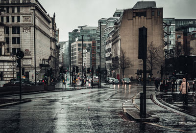 Street amidst buildings in city during rainy season