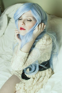 Close-up of young woman lying on bed at home