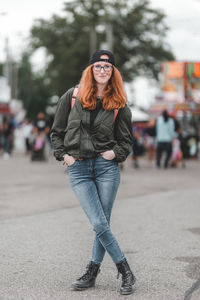 Portrait of young woman standing on road