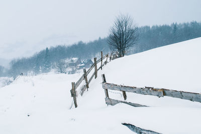 Scenic view of snow covered field against sky