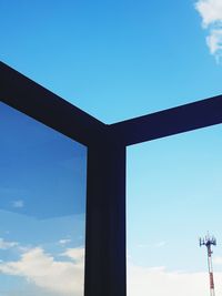 Low angle view of silhouette sculpture against blue sky