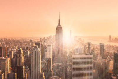 Aerial view of buildings in city against sky during sunset