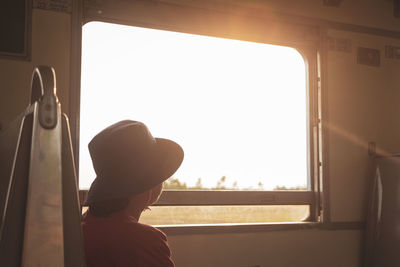 Rear view of man seen through train window