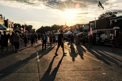 People celebrating festival on road against sky