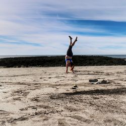 Full length of woman on beach against sky