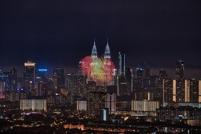 Illuminated cityscape against sky at night