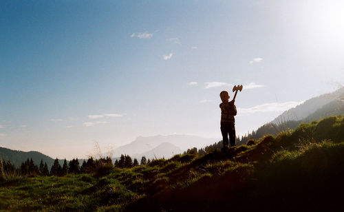 Old fashioned, vintage, film photography on dolomite, little boy play with his wooden ax