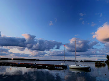 Sailboats in sea against blue sky