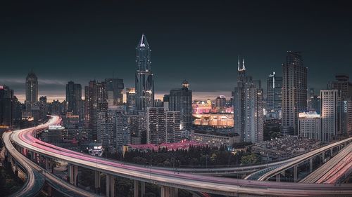 High angle view of illuminated highway amidst buildings in city at night