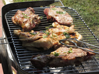 High angle view of chicken and steaks on barbecue