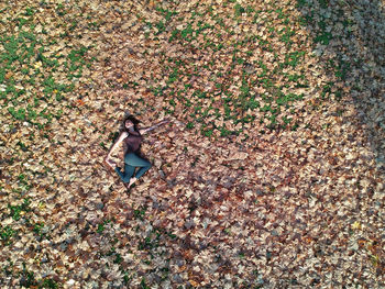 Directly above shot of woman lying on autumn leaves