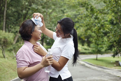 Daughter wiping mother sweat after exercising