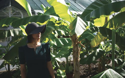 Side view of woman standing against plants