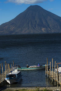 Boats moored at shore against sky