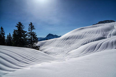 Snow covered landscape against sky
