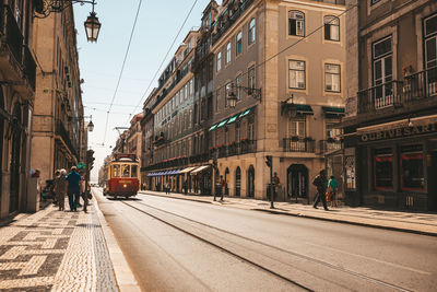 Tramway on street amidst buildings in city