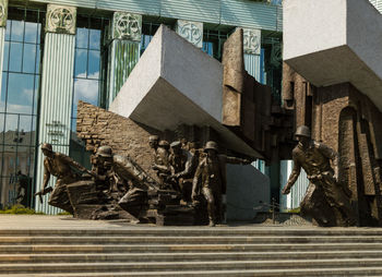 Low angle view of statue against buildings in city