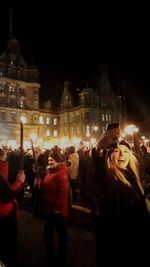 People photographing illuminated cityscape at night