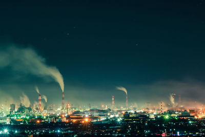 Smoke emitting from factory against sky at night