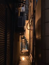 Narrow alley amidst buildings at night