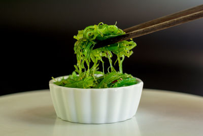 Close-up of green juice on table against black background