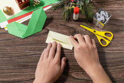 High angle view of woman hand holding paper at table