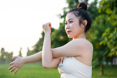 Young woman exercising on field