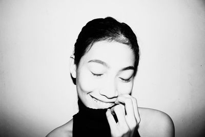 Close-up portrait of young woman against white background