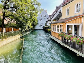 Canal amidst buildings against sky