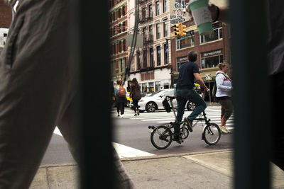 People riding bicycle on street in city