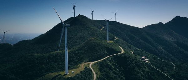 Wind turbines on land against sky