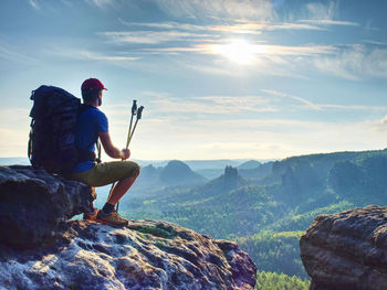 Rear view of man on rock against sky