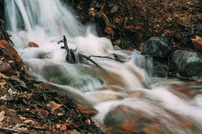 High angle view of stream flowing through rocks