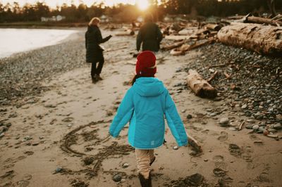 Rear view of girl walking at beach