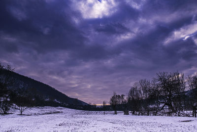 Scenic view of snow covered field against sky