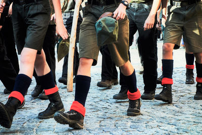 Low section of people in uniform walking on street