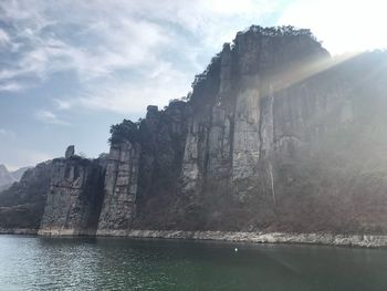 Rock formations by sea against sky