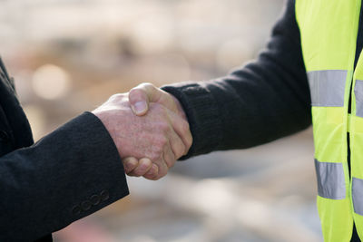 Cropped image of people shaking hands in city