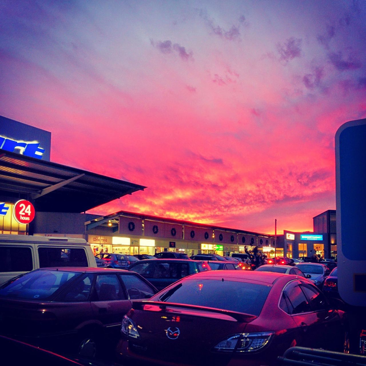 car, land vehicle, transportation, sunset, mode of transport, building exterior, sky, architecture, built structure, street, city, traffic, cloud - sky, road, illuminated, orange color, dusk, city street, outdoors, city life