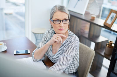 Portrait of young woman using mobile phone at home