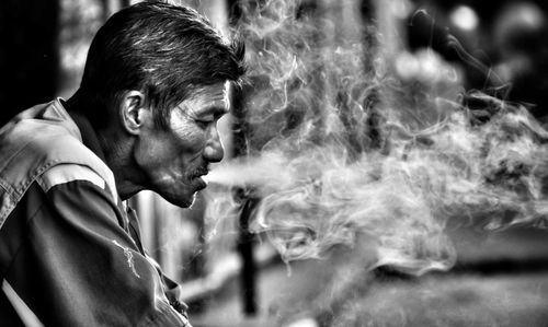 Portrait of young man smoking cigarette outdoors