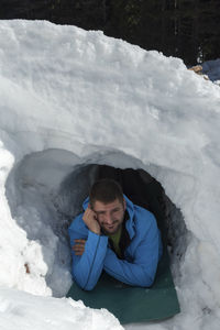Portrait of man lying in snowy cave