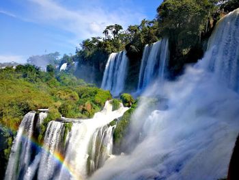 Scenic view of waterfall against sky